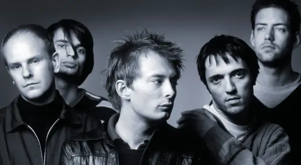 Czarno-białe zdjęcie zespołu Radiohead, pięciu mężczyzn pozujących do portretu.