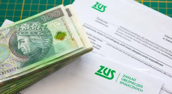 Stos dokumentów ZUS i plik banknotów 100 zł. Zastanawiasz się, ile wynosi składka ZUS dla jednoosobowej firmy?