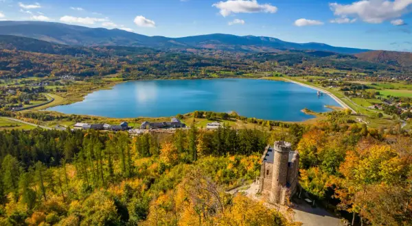 Widok na zamek, jezioro i jesienne Karkonosze.