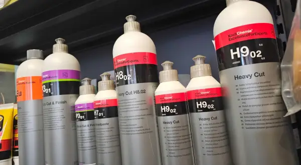 Butelki z pastą polerską Koch Chemie, w tym Heavy Cut H9.02 i Micro Cut & Finish P3.01, stoją na półce.