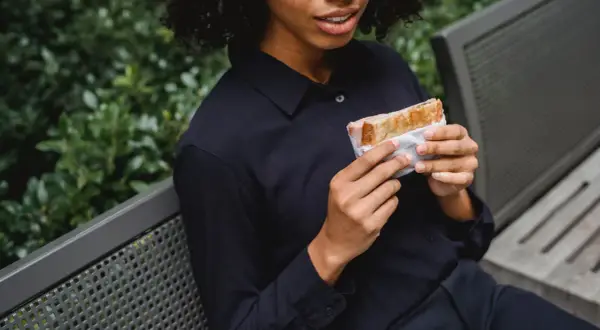 Frau hält Sandwich, wie bei der Sandwich-Methode für Feedback.