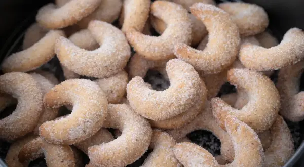 Ein Haufen zarter Vanillekipferl, bestreut mit feinem Zucker, wartet darauf, genossen zu werden.