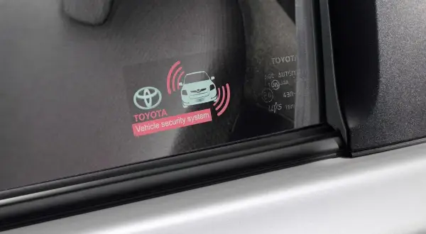 Naklejka na szybie Toyoty z symbolem samochodu i falami, informująca o systemie bezpieczeństwa. Działa dzięki bluetooth low energy, jak działa?