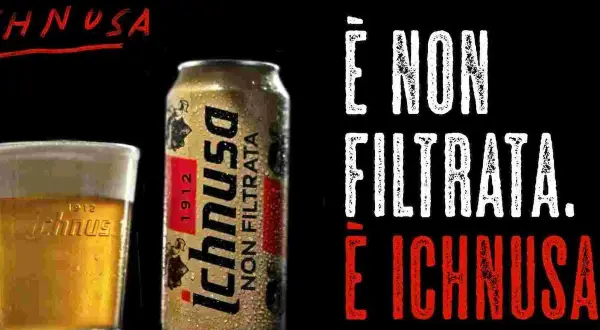 A glass of Ichnusa beer and a can of Ichnusa Non Filtrata beer on a black background.