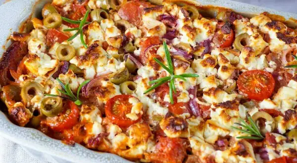 Herzhafter Kritharaki Auflauf mit Feta, Oliven, Tomaten und Rosmarin, goldbraun gebacken.