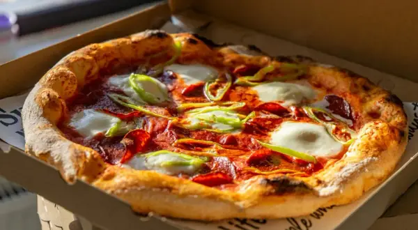 Pyszna pizza z pepperoni, mozzarellą i papryką w pudełku. Idealna na wieczór, gdy zastanawiasz się, skąd pochodzi pizza.