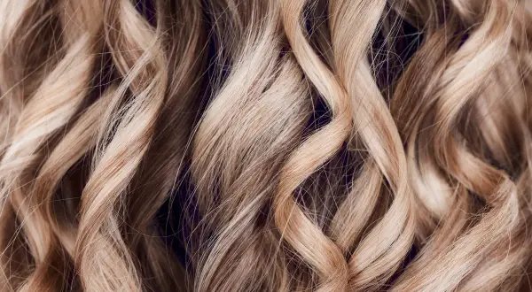 Falujące, blond włosy z subtelnymi refleksami, jak po letnim słońcu. Technika flamboyage nadaje im naturalny, trójwymiarowy efekt.
