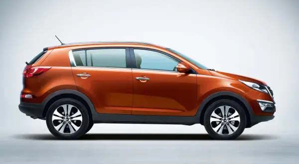 Pomarańczowy Kia Sportage 2015 z profilu, gotowy na przygodę.
