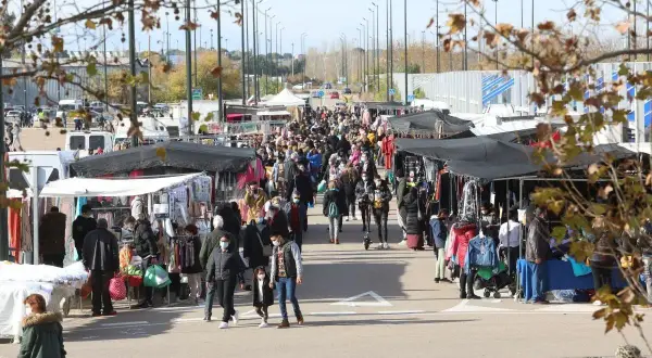 Gente paseando y comprando en un bullicioso mercadillo al aire libre cerca del auditorio de Zaragoza.