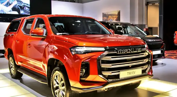 Pomarańczowy Maxus T90 EV, chińska marka samochodów w Polsce, prezentuje się na wystawie.
