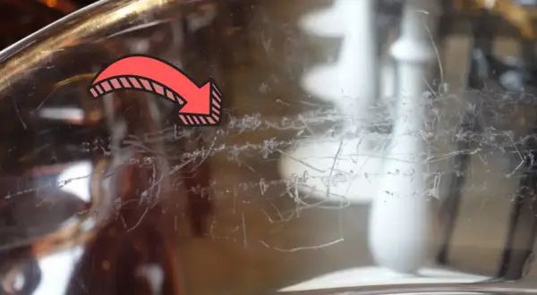Flèche rouge indiquant des traces de peinture à enlever sur du verre.