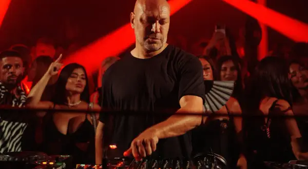 DJ calvo mixa musica al Pacha, con la folla che balla e si diverte sotto le luci rosse.