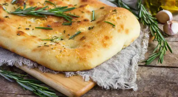 Un pain italien traditionnel, doré et moelleux, garni de romarin frais et d'ail. Parfait pour accompagner un repas.