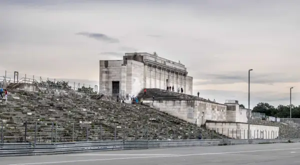Besucher erkunden die imposanten Steintribünen und das monumentale Gebäude der Nürnberger Reichsparteitagsgelände.