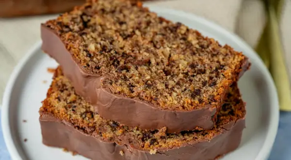 Zwei Scheiben schoko nuss kuchen mit Schokoladenglasur auf einem Teller.
