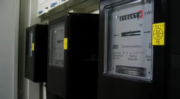 Trzy liczniki energii elektrycznej, jeden z nich pokazuje 3104572 kWh.