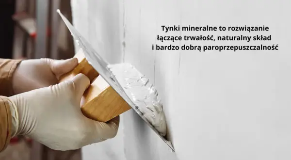 Ręce w rękawiczkach nakładają tynk na ścianę kielnią. To obrzutka, która zapewnia trwałość i paroprzepuszczalność.