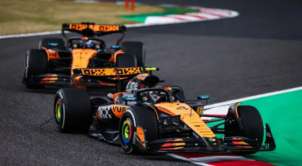 Dos coches de Fórmula 1 de McLaren, con el equipo de Andrea Stella, compiten en una curva.