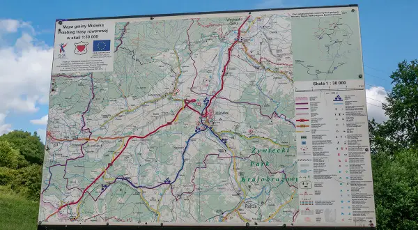 Mapa gminy Milówka pokazuje przebieg niebieskiego szlaku rowerowego. Widać liczne drogi i ścieżki, a także legendę z symbolami.