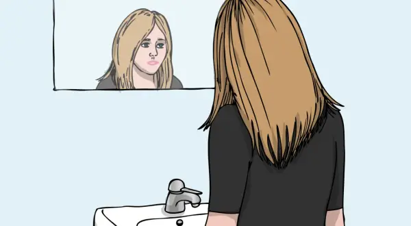 En ung kvinna med blont hår ser sig i spegeln, hennes ansiktsuttryck tyder på oro. Kanske kämpar hon med tankar relaterade till ocd svenska.