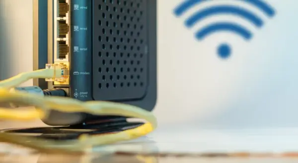 Czarny router z wieloma portami LAN i ikoną Wi-Fi. Ten wzmacniacz internetu zapewnia stabilne połączenie.