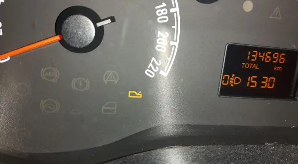 Kontrolki w Oplu: ABS, hamulec, poduszka, drzwi, bagażnik. Na wyświetlaczu przebieg 134696 km i czas 15:30.