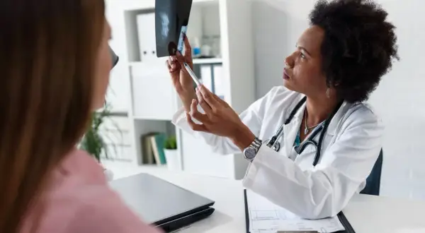 Lekarka omawia z pacjentką wynik mammografii, wskazując na zmiany. BIRADS 5 rokowania wymaga dalszej diagnostyki.