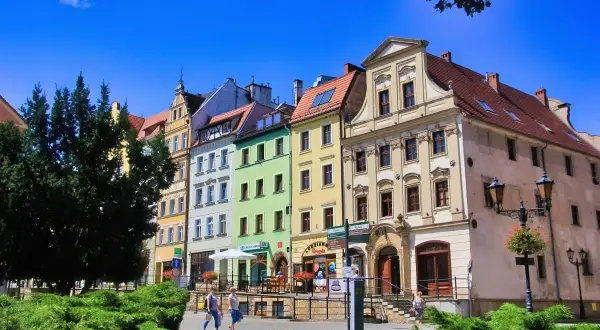 Kolorowe kamienice na rynku w Złotoryi, zachęcające do spaceru i odkrywania urokliwych zakątków. Złotoryja atrakcje czekają!
