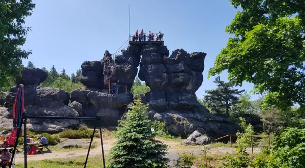 Menschen erklimmen eine Aussichtsplattform auf bizarren Felsen. Ein tolles Ziel für Görlitz Wandern.