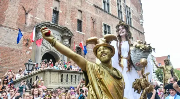 Złoci aktorzy na jarmarku świętego dominika w Gdańsku, tłum widzów z aparatami.