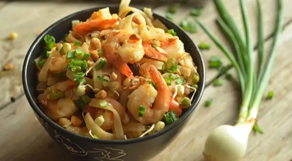 Pyszny pad thai z krewetkami, posypany szczypiorkiem i orzeszkami. Idealny przepis na szybki obiad.