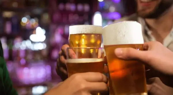 Brindisi con birra in un locale. Forse dopo un bicchiere, la birra fa dormire bene.