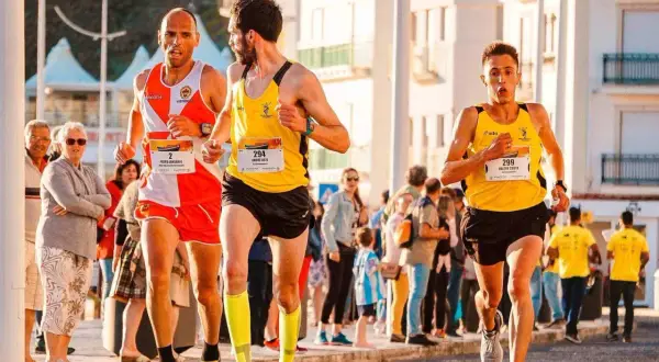 Trzech biegaczy w żółtych i pomarańczowych strojach walczy o zwycięstwo w maratonie. Czy pobiją rekord świata?