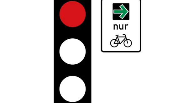 Rote Ampel zeigt Stopp an. Ein Schild mit Pfeil nach rechts und Fahrradsymbol bedeutet: Nur Radfahrer dürfen hier weiterfahren. Wer hat Vorfahrt?