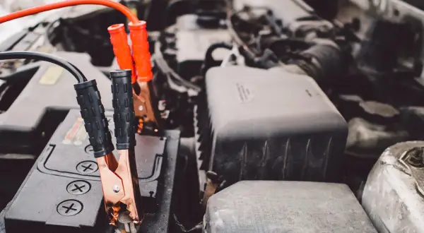 Kable rozruchowe podłączone do akumulatora samochodowego. Rozpoczyna się budowa akumulatora, by uruchomić auto.