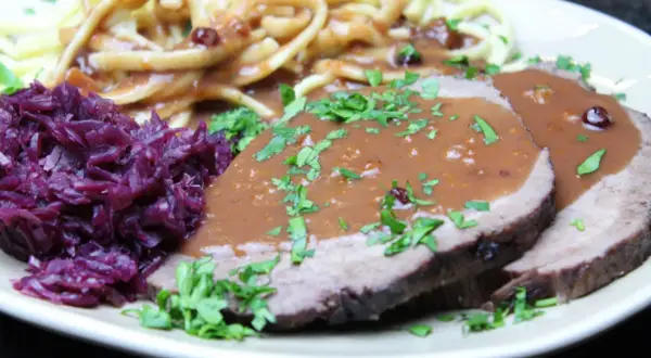 Sauerbraten rezept: Zarte Scheiben Braten mit dunkler Soße, dazu Rotkohl und Spätzle. Ein Klassiker der deutschen Küche.