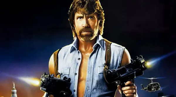 Chuck Norris w akcji, gotów do strzału z dwóch pistoletów maszynowych. Klasyka jego filmów akcji.