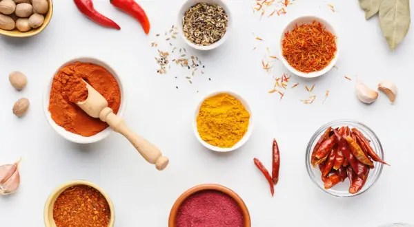 Miseczki z przyprawami: papryka, kurkuma, szafran, chili. Ile procent ostrości w tej warkocze czerwonej?