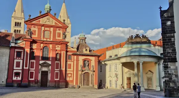 Visite à Prague : la place pavée devant la basilique Saint-Georges et le monastère, avec des touristes se promenant sous un ciel bleu.