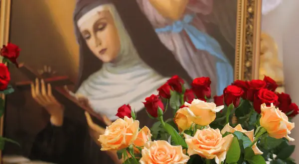 Obraz przedstawia świętą Ritę, patronkę trudnych spraw, z krzyżem w dłoniach. Wokół bukiety róż, symbolizujące jej życie.