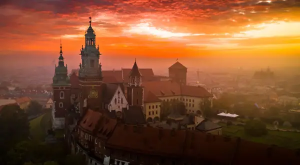 Wawel o wschodzie słońca, z ognistym niebem i mgłą unoszącą się nad miastem. Czuć energię czakramu wawelskiego.