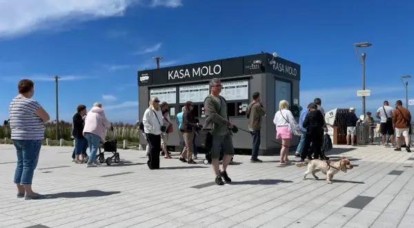 Kasa Molo w Kołobrzegu. Ludzie stoją w kolejce, by dowiedzieć się, czy molo w Kołobrzegu jest płatne.