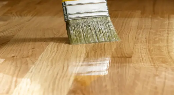 Pennello applica vernice su legno, creando una finitura satinato significato.
