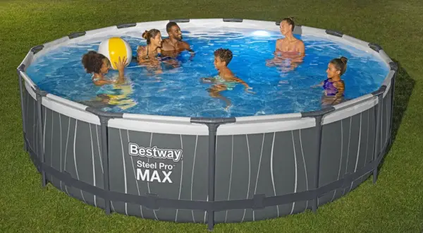 Rodzina pluska się w okrągłym basenie naziemnym Bestway Steel Pro MAX na trawniku.