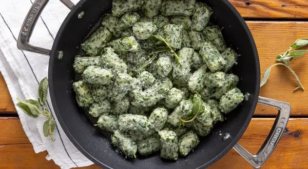 Strangolapreti alla trentina fumanti in padella, conditi con burro fuso, salvia e parmigiano.