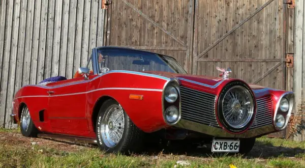 Röd cabriolet med kromade detaljer och ekrade fälgar, en unik skapelse bland rambler bilmodeller.