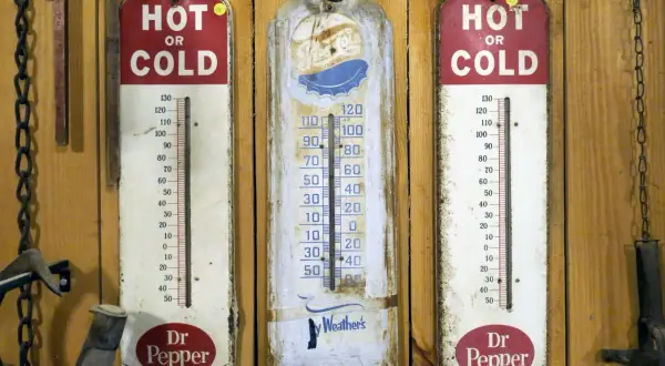 Trzy stare termometry wiszą na drewnianej ścianie. Dwa z nich reklamują Dr Pepper, jeden pokazuje "Ay Weather's". Idealne do monitorowania temperatury w biurze.