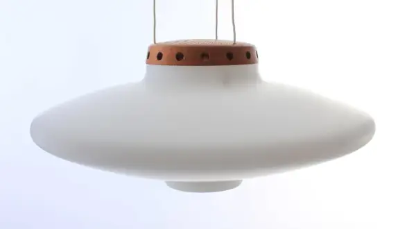 En vit, svävande ufo lampa med en trädetalj upptill.