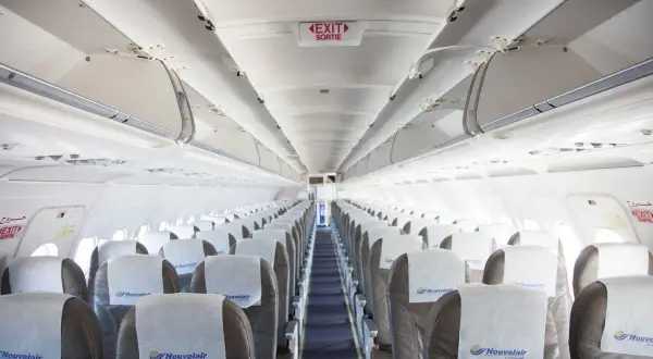 Puste siedzenia w samolocie linii nouvelair, gotowe na pasażerów.