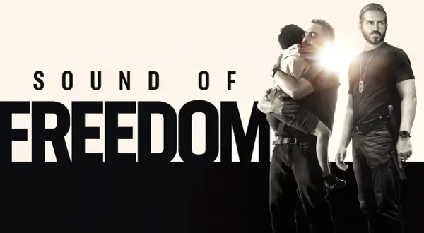 Sound of Freedom" Stream: Ein Mann umarmt ein Kind, während ein Polizist daneben steht.